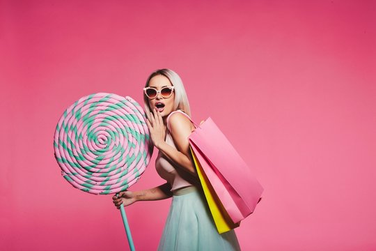 Model posing with with sweets and shopping bags