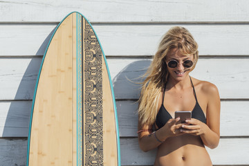 Woman Surfer Typing on Cell Phone