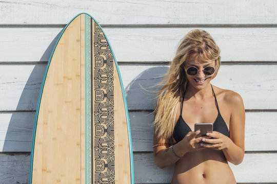 Woman Surfer Typing On Cell Phone