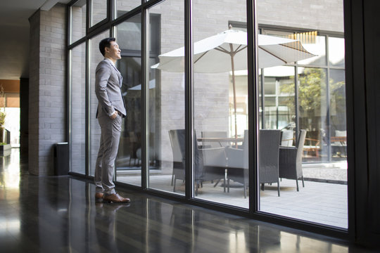 Confident businessman looking through window