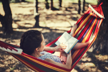 teenager girl lay in hammock with book and kitten outdoor summer garden photo