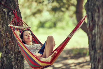 teenager girl lay in hammock with book and kitten outdoor summer garden photo