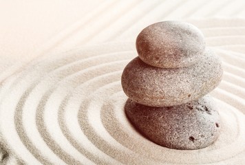 Fototapeta na wymiar Zen stones in the sand. Beige background