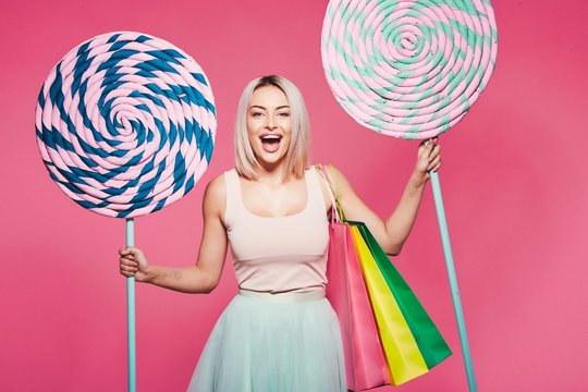 Beautiful  model with sweets at pink background