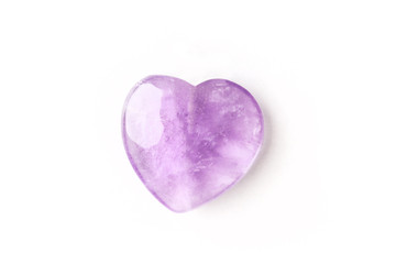 Overhead photo of a purple amethyst crystal heart on a white background with copy space