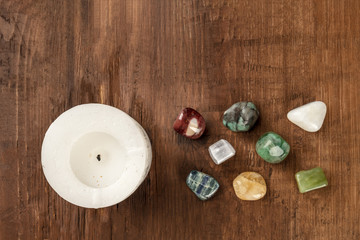 An overhead photo of gemstones with a candle, healing stones