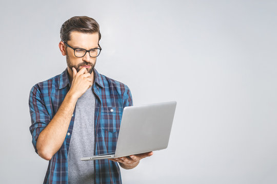 Confident business expert. Confident young handsome man in shirt holding laptop while standing against white background