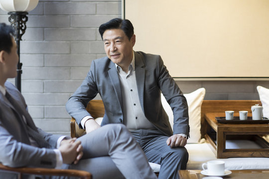 Businessmen talking with each other in office