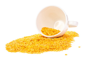 Lot of whole raw red lentils with ceramic cup isolated on white background
