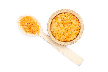 Lot of whole raw red lentils and spoon with wooden bowl flatlay isolated on white background