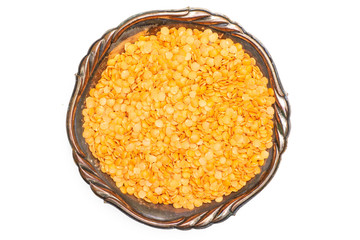 Lot of whole raw red lentils in old iron bowl flatlay isolated on white background