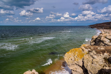 Wild beach of the Black Sea in Crimea against the blue sky -1