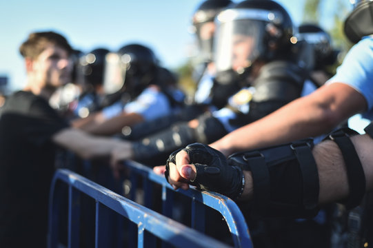  Security staff hands on a protection fence during a riot