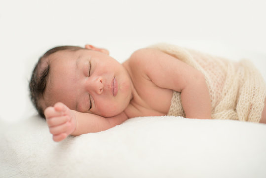 Cute newborn baby sleeping on a blanket - happy family moments concept