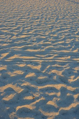 Yellow sand of the black sea at sunset with a blue shadow and golden color, very ordinary background