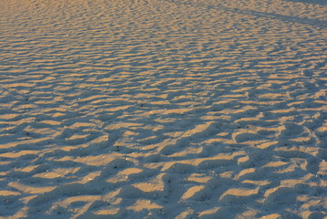 Fototapeta na wymiar Yellow sand of the black sea at sunset with a blue shadow and golden color, very ordinary background