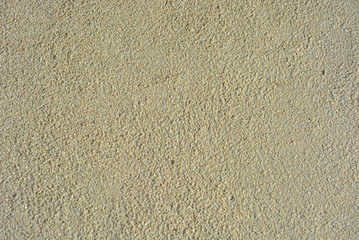 Yellow bright background, construction wall with very small glass stones matte white and gray with a reflection of the sun