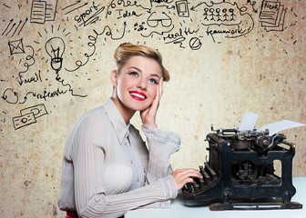 Attractive young woman working on vintage typewriter