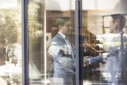 Confident businessmen shaking hands