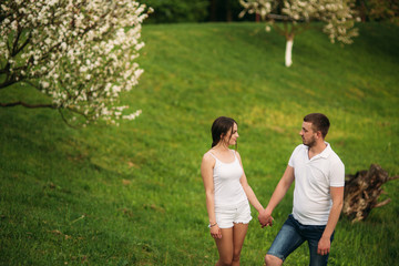 Dating in park. Love couple standing together on grass near the lake. Romance and love