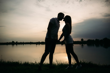 Fototapeta na wymiar Silhouette of beautiful couple. lake in background