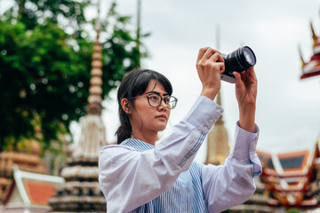 Asian woman solo travelers and take photo ancient pagoda buildings- Wat pho temple- Bangkok...