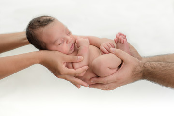 Cute newborn baby sleeps in the hands of parents protected and safe - happy family moments for mom...