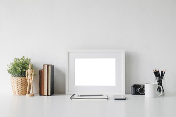Stylish workspace with poster, book and gadget. Workplace desk and copy space.