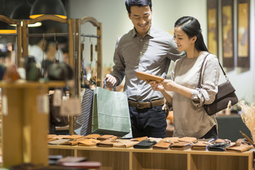 Happy young couple shopping in leather shop