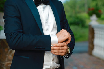 Grooms morning preparation, handsome groom getting dressed and preparing for the wedding, in suit