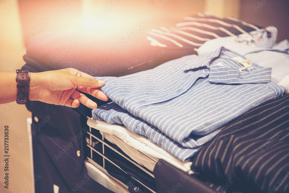 Wall mural hand of customer choosing clothes in a clothing store