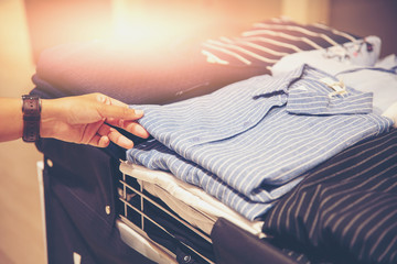 Fototapeta premium hand of customer choosing clothes in a clothing store