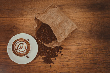 Hot coffee latte art with pattern on top by flat lay photography, warm feeling coffee, vintage cup with light flare