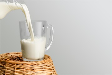 Glass jug of fresh milk  on background