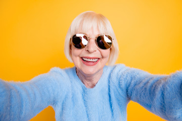Close up portrait of happy grandma taking a selfie on vacation o