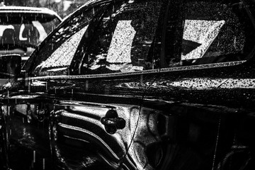 Schwarzes Auto im Gegenlicht bei starkem  Regen