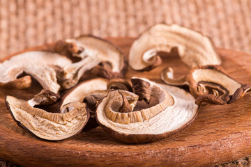 Dried white mushrooms on a wooden spoon. Dried porcini mushrooms.