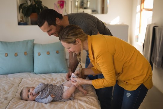 Father and mother dressing their baby boy