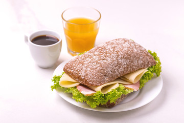 Chiabatta sandwich, coffee and orange juice. Breakfast. Selective focus
