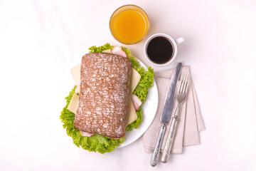 Chiabatta sandwich, coffee and orange juice. Breakfast. Selective focus