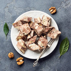 Oriental sweet dessert. Eastern halva on a white plate. Top view.