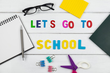 Top view of Let's go to school wording on wooden background