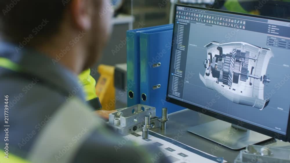 Leinwandbilder Close-up Back View of the Mechanical Engineer Designing 3D Engine Model on Personal Computer. Professional Working At the Factory.