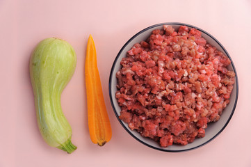 Natural raw ingredients for pet food on pink background.