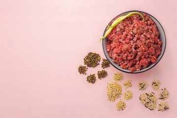 Natural raw ingredients for pet food on pink background.