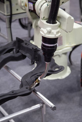 Industrial robot arm welding car part in factory. Automotive industry