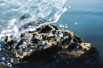 Water wave splashes, against a clear blue sky background