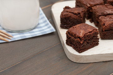 homemade cake chocolate brownies and milk on wooden table