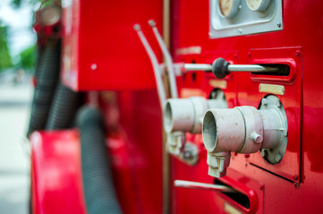 closeup pipe hydrant on a fire truck with soft-focus and over light in the background