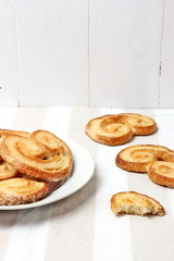 Spanish palmiers on a plate with a cup, light colors